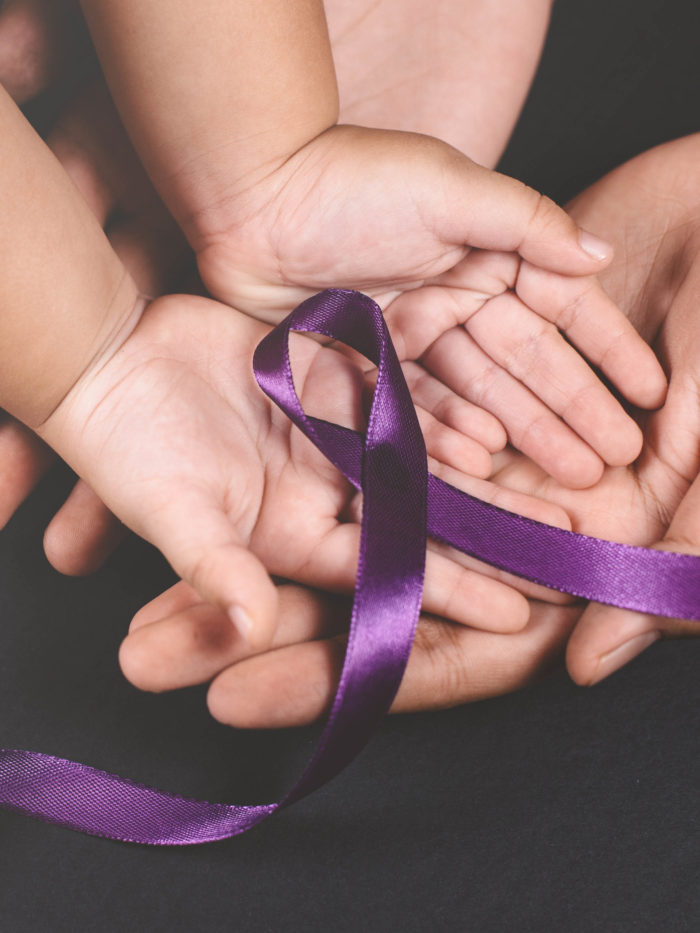 child hand holding Purple ribbon on adult caring hand