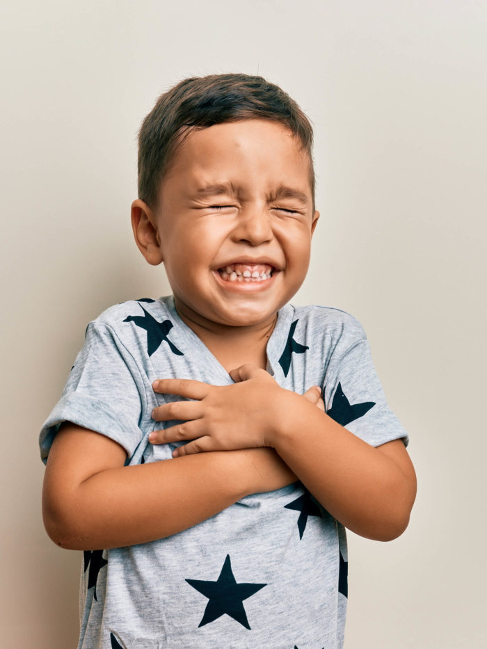 little boy touching his chest in pain