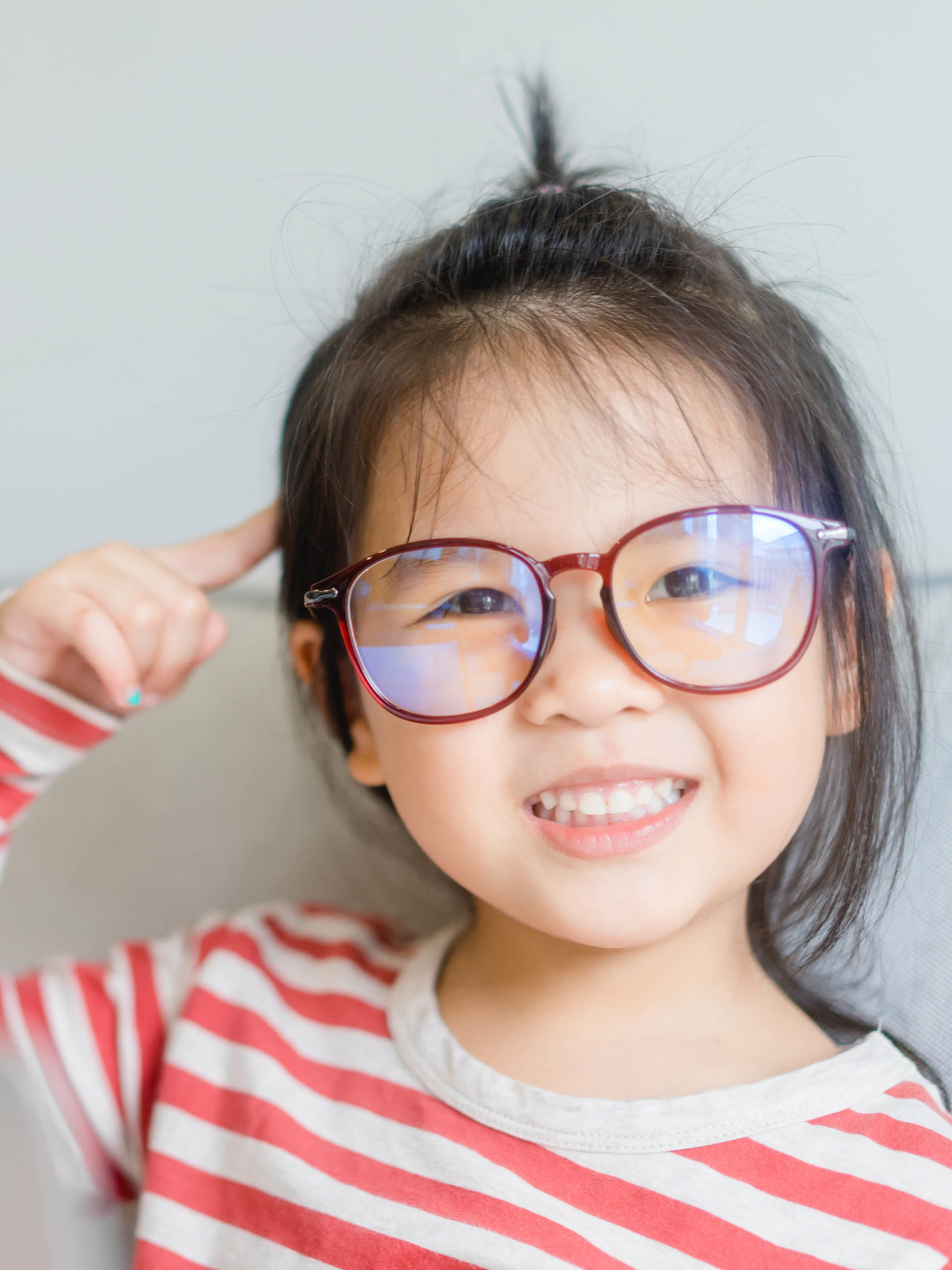 girl wearing glasses pointing finger at brain