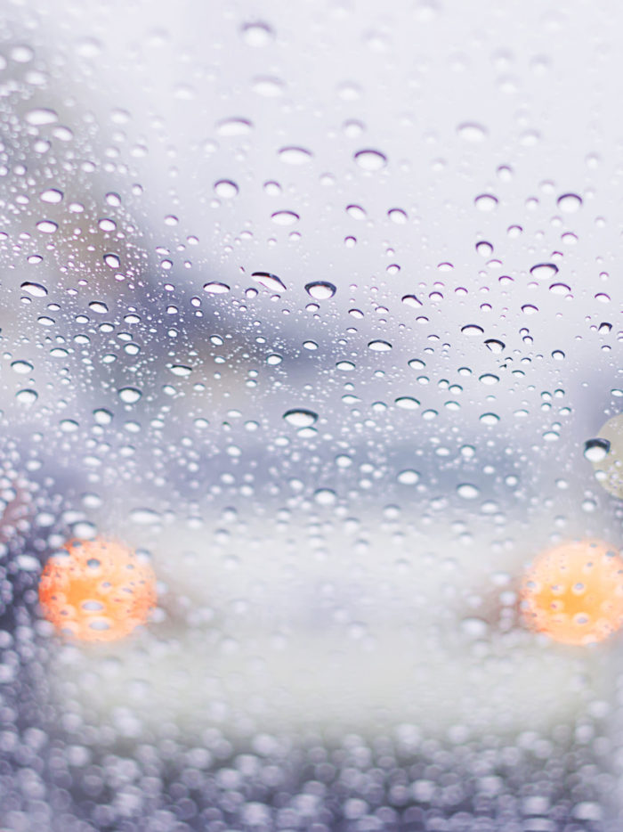 car window covered in rain drops