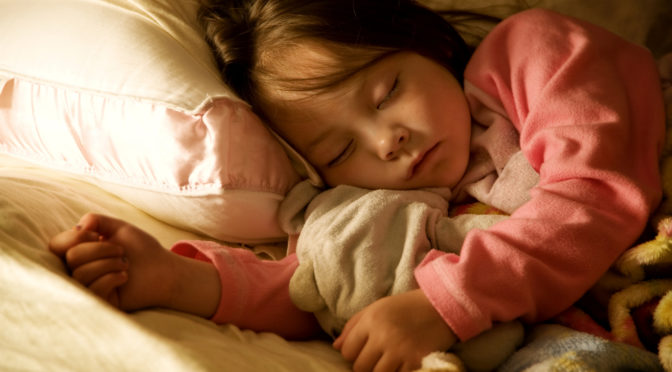 a young girl fast asleep in bed