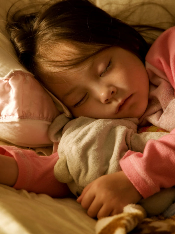 a young girl fast asleep in bed