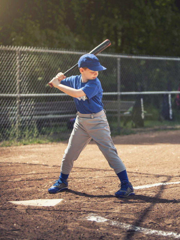 young boy playing baseball up to bat
