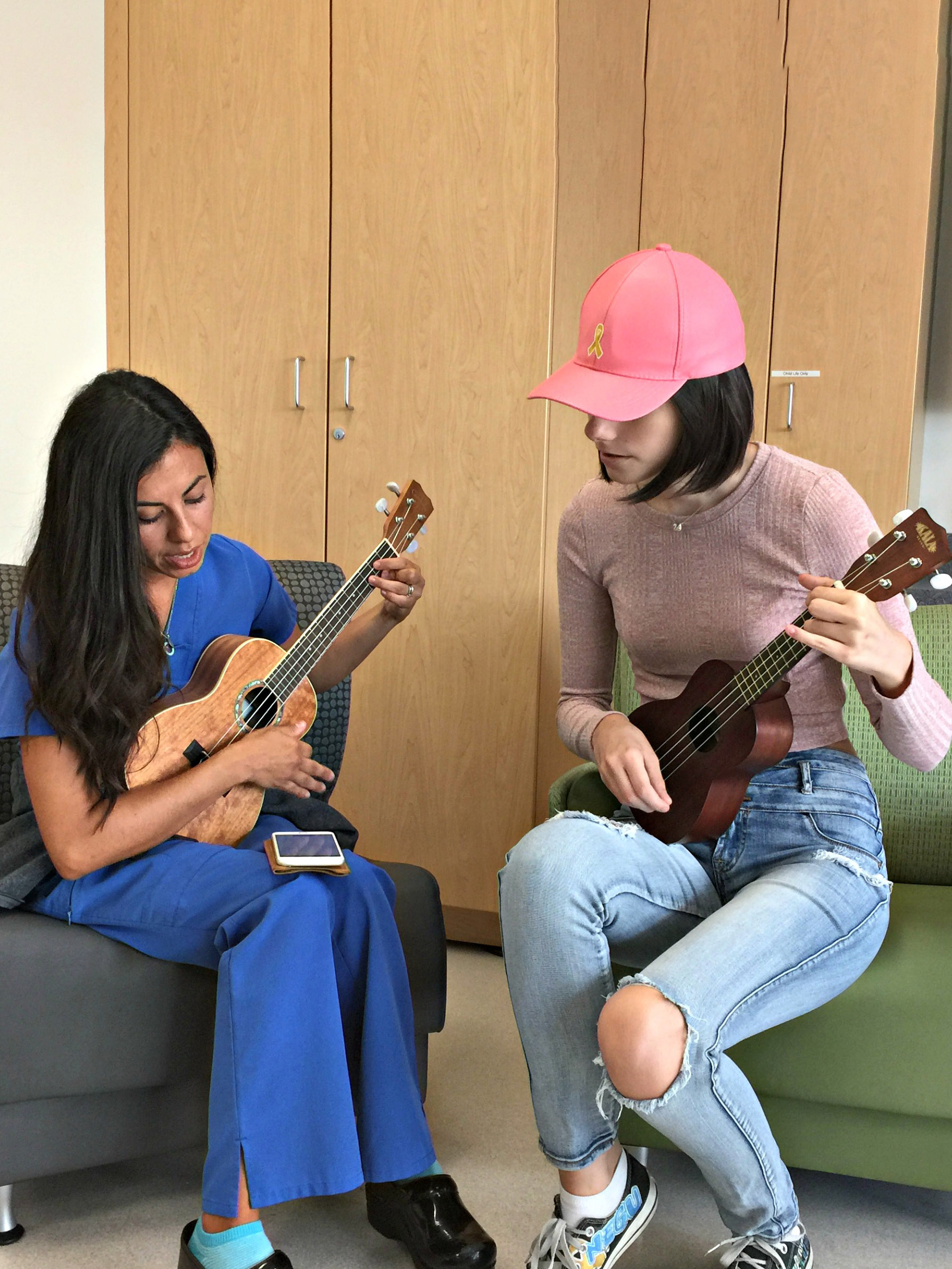 CHOC nurse Erika playing a song on ukelele with CHOC patient Christine