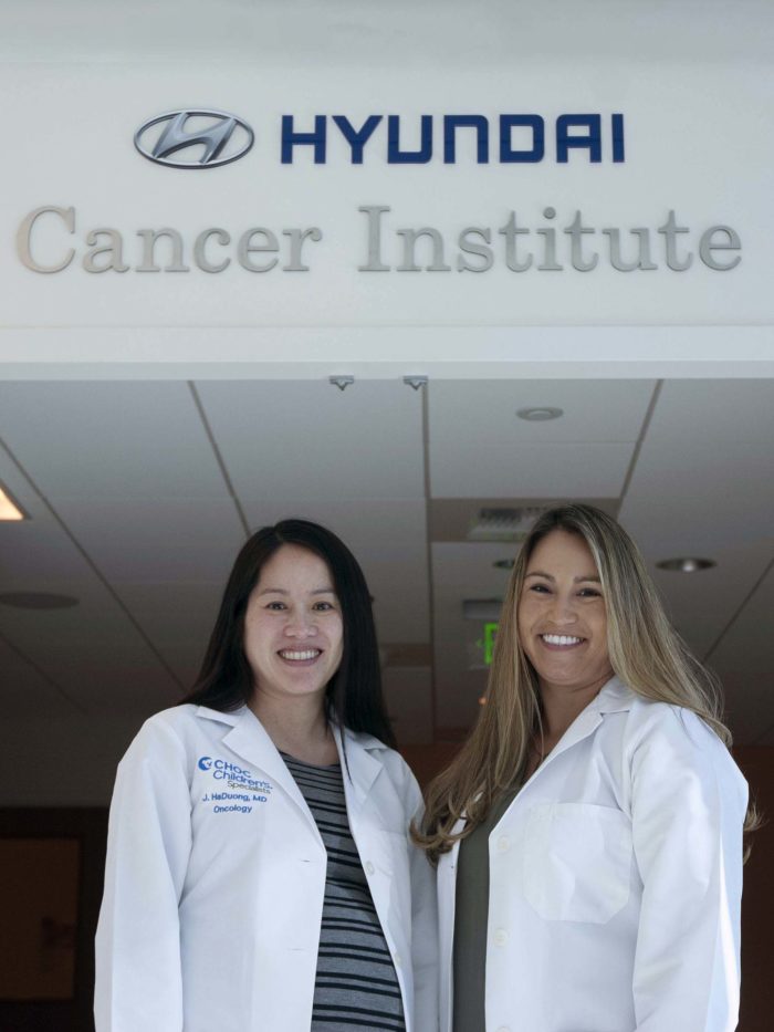 Dr. HaDuong and Dr. Plant standing in front of the Hyundai cancer institute at CHOC