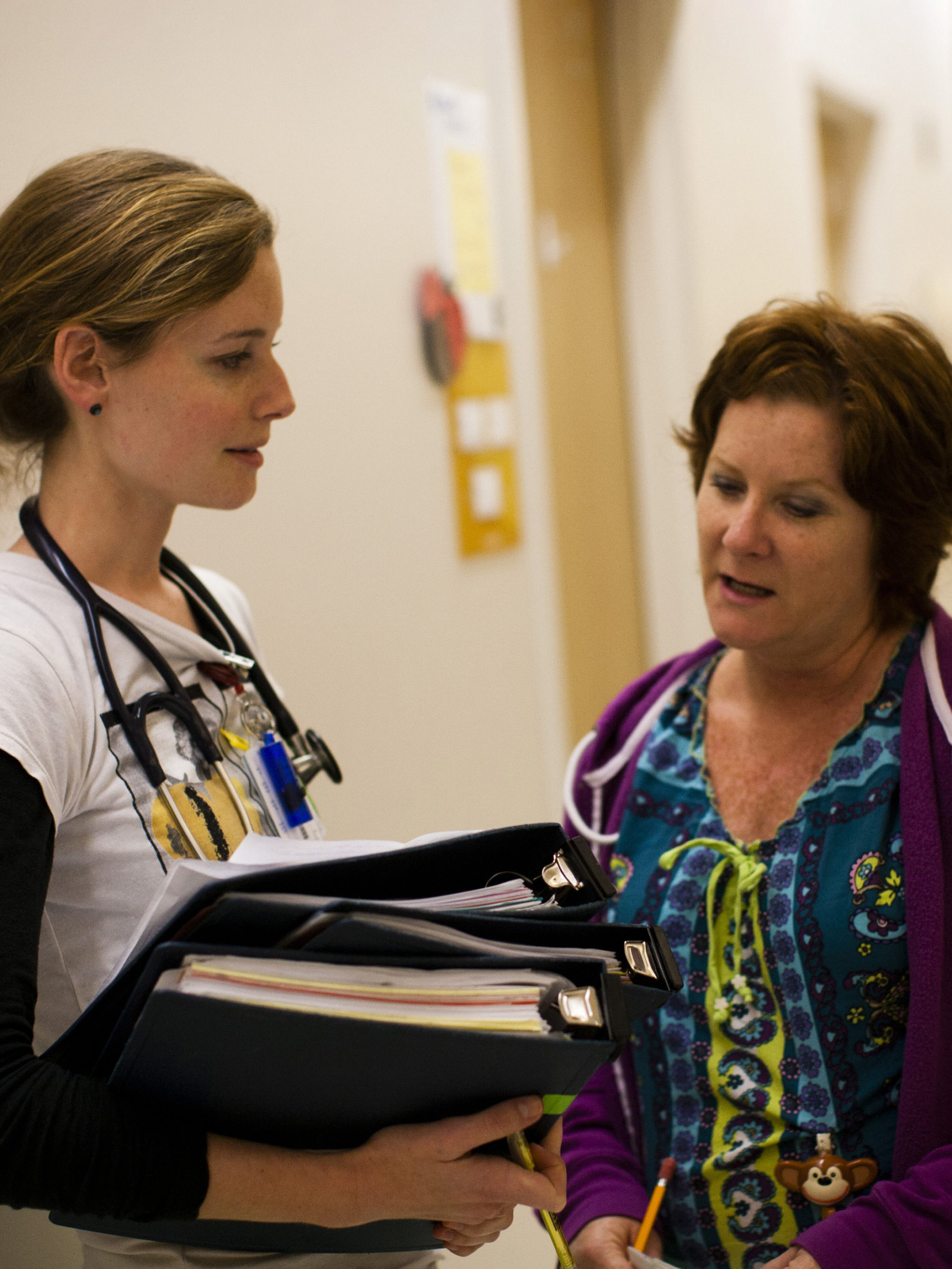 two CHOC nurses in hallway discussing patient care