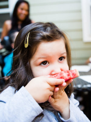 Little girl eating watermelon outdoors