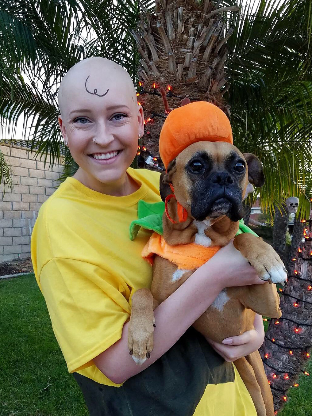 CHOC patient Brianna dressed like Charlie Brown celebrating Halloween with her dog