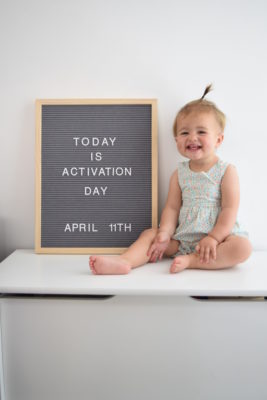 Gracie smiling next to sign that says "Today is activation day, April 11"