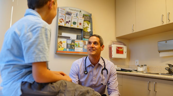 young patient with Dr. Eric Ball at a doctor's appointment