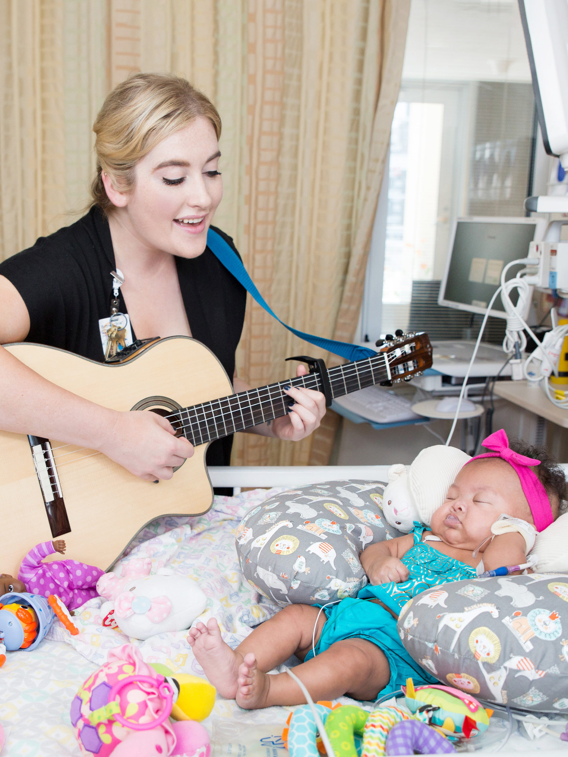 o Brie Mattioli, a board-certified music therapist at CHOC playing music for Olivia, a NICU patient