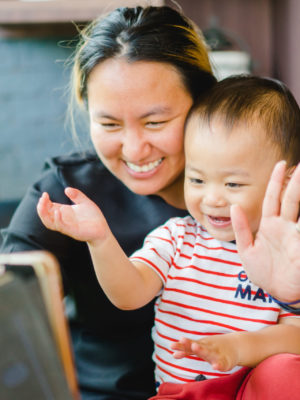 mother and baby having a video chat and waving