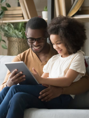 father and daughter using a table to have a telehealth appointment