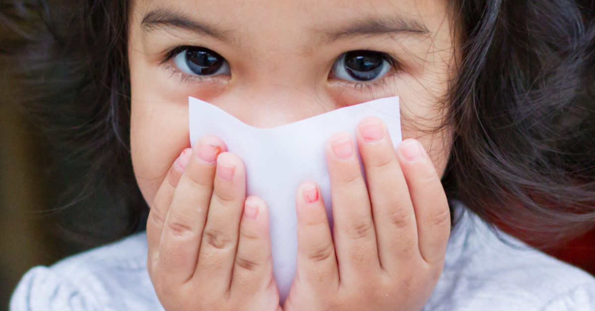 little girl covering her mouth with a post it