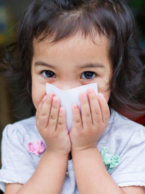 little girl covering her mouth with a post it