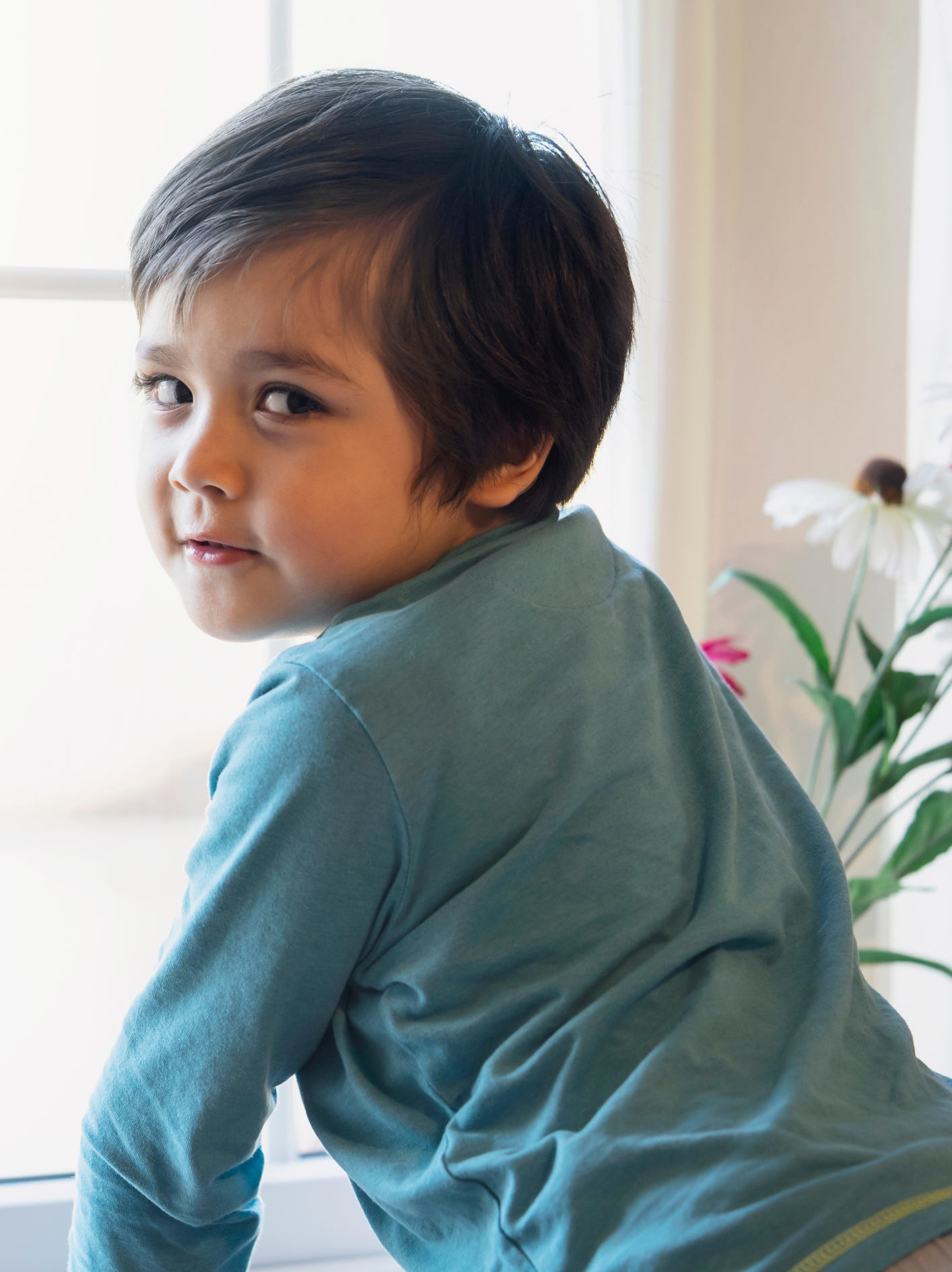 young boy in front of an open window