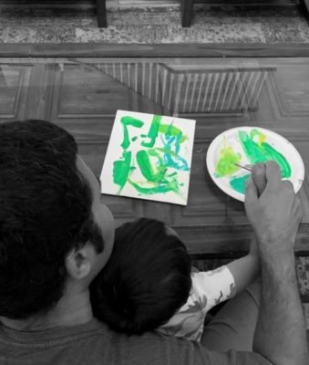 father and child having family art time in living room