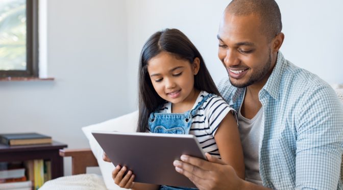 Father and daughter on tablet for telehealth appointment