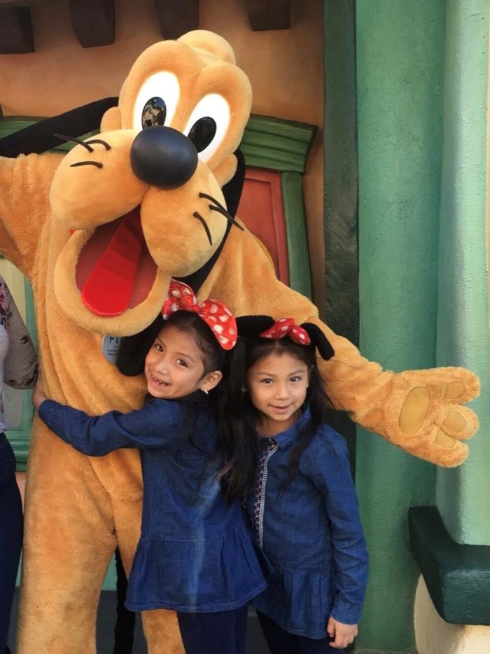 Naomi and twin sister Natalie at Disneyland with Pluto