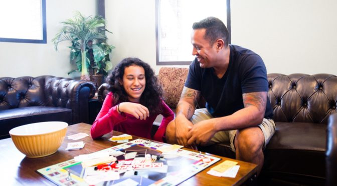 father and daughter playing monopoly for family game night
