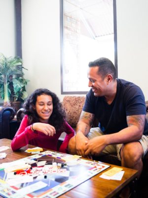father and daughter playing monopoly for family game night