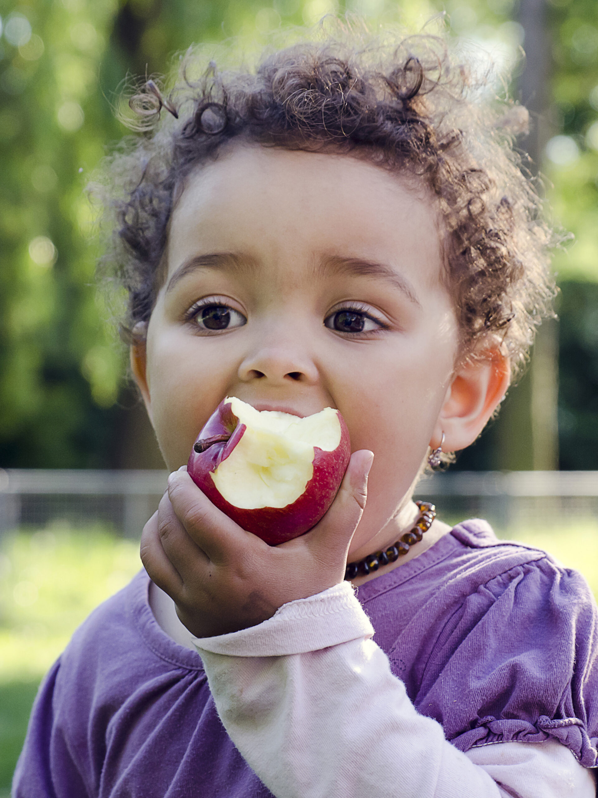 Young girl eating apple - healthy snack ideas for kids from CHOC dietitians