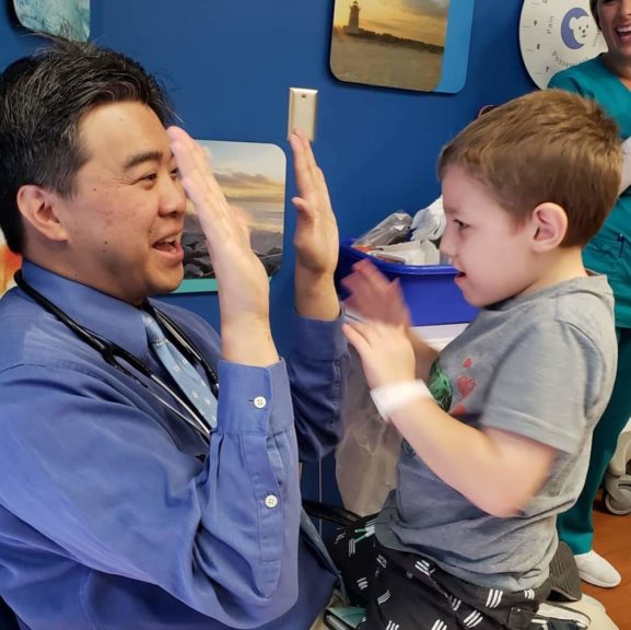 Dr. Raymond Wangs gives patient Ely a high-five