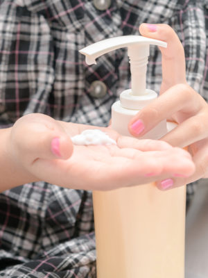 girl putting lotion on hands