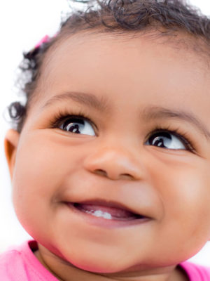 closeup of baby smiling with only two bottom teeth