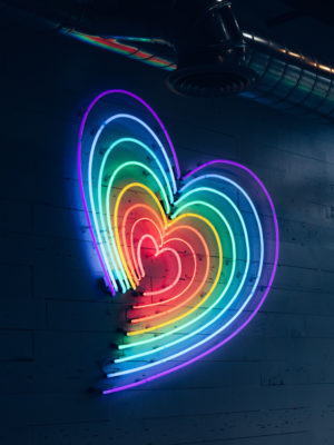 neon light in the shape of heart in a rainbow of colors