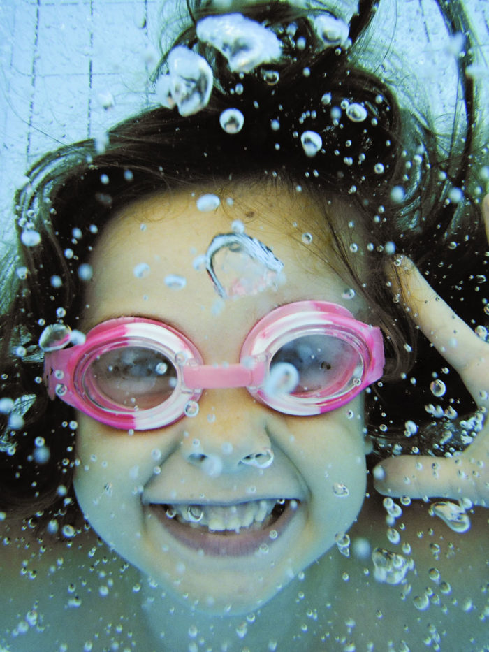 Underwater portrait of a smiling 6-year-old girl