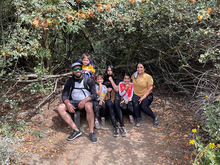 Group image of a family smiling while on a hike. 