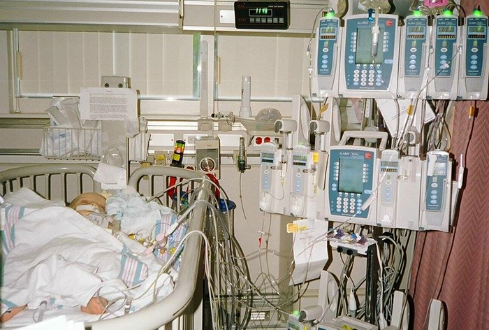 Baby lays in bed hooked up to several monitors at hospital 
