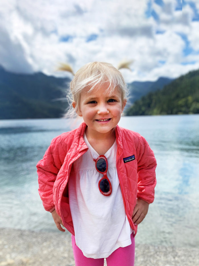 Little girl smiling in front of a lake