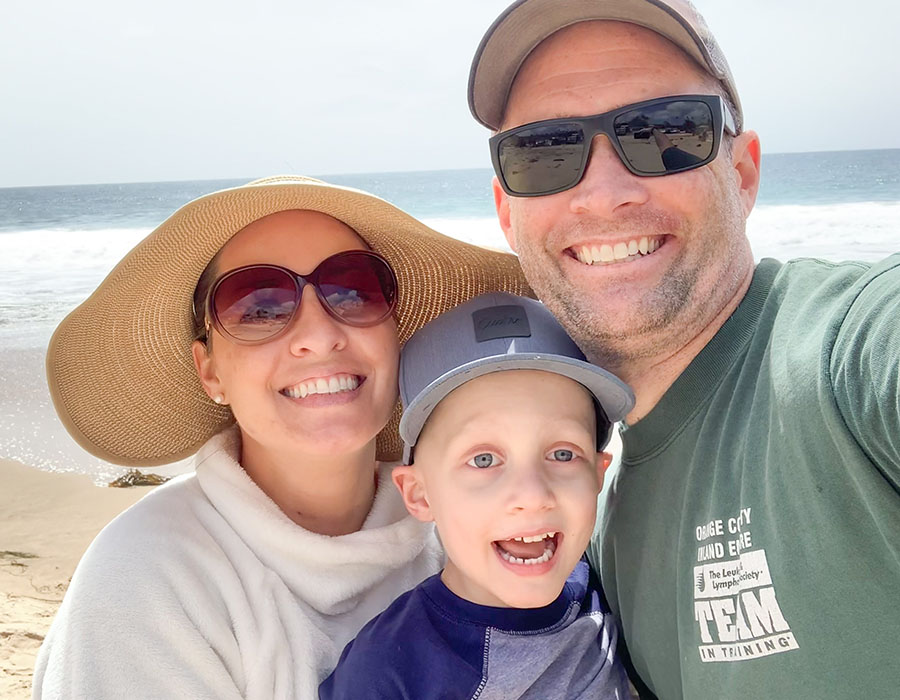 Parents and son smiling for a selfie at the beach 