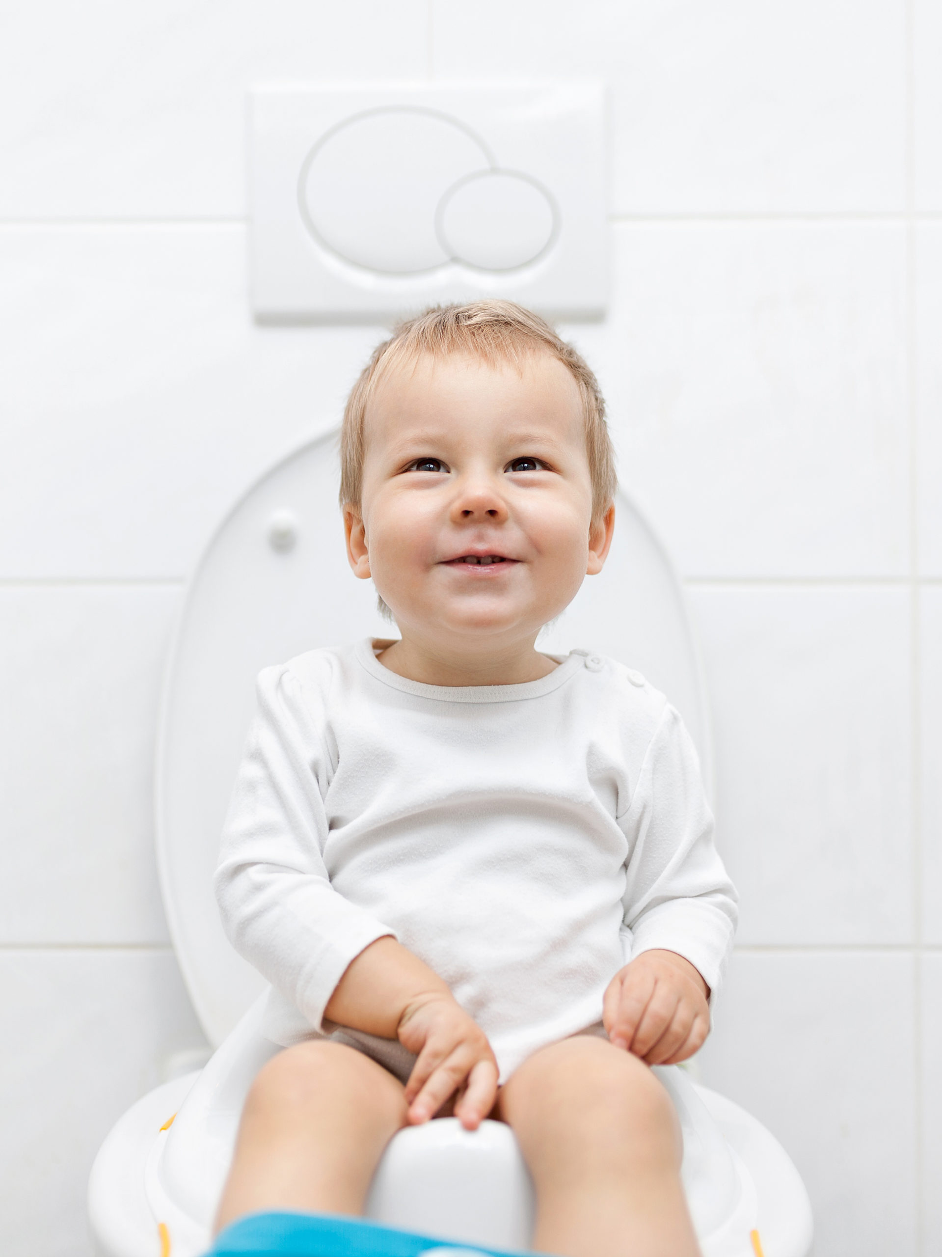 toddler smiles while using training toilet
