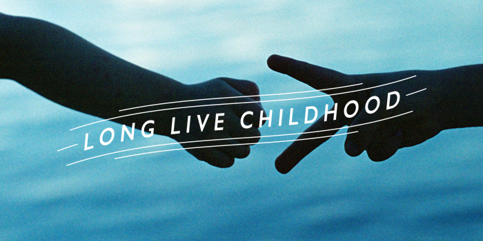 kids playing paper scissors rock with long live childhood banner