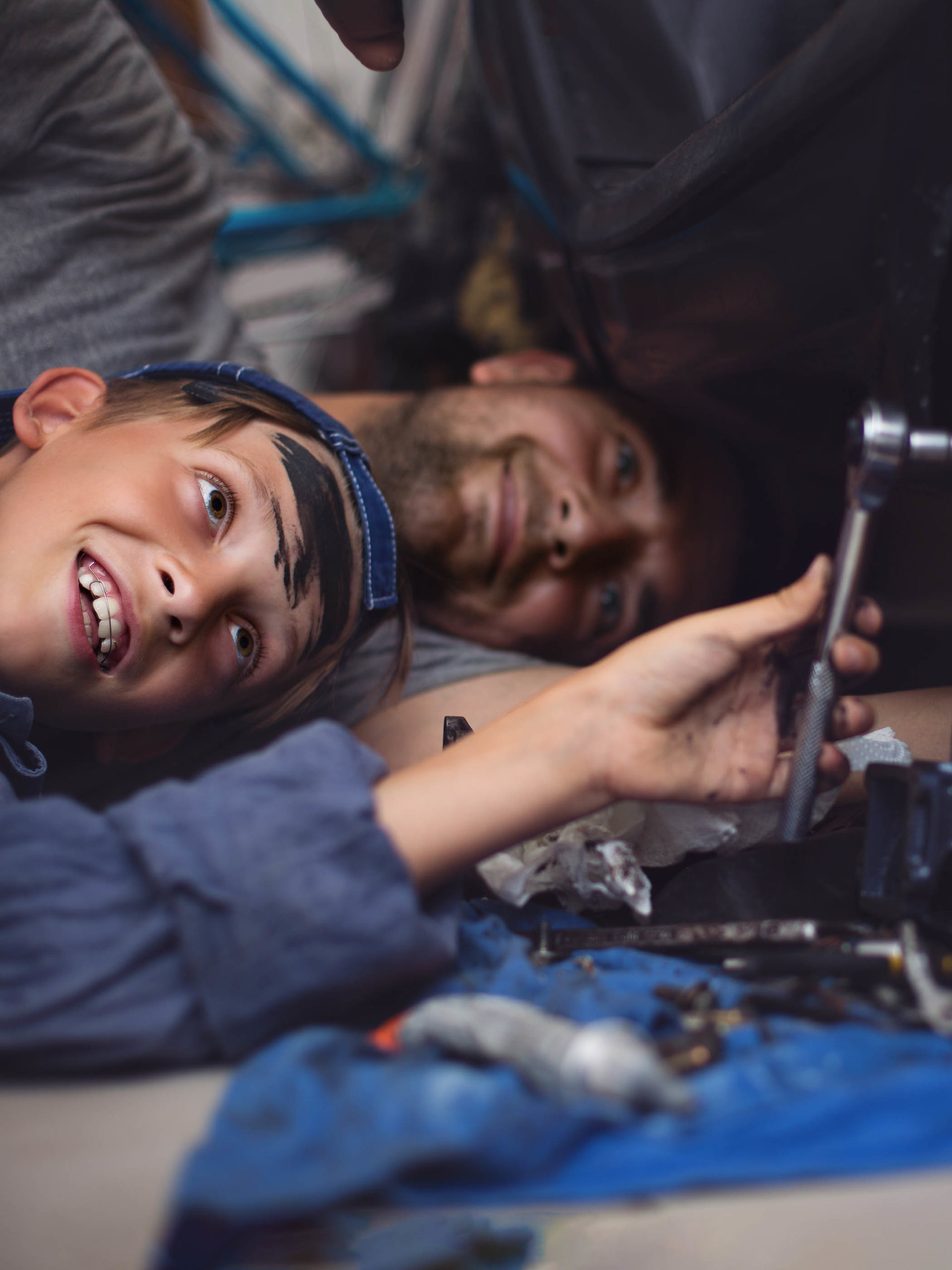 Father mechanic with son examining car in the garage