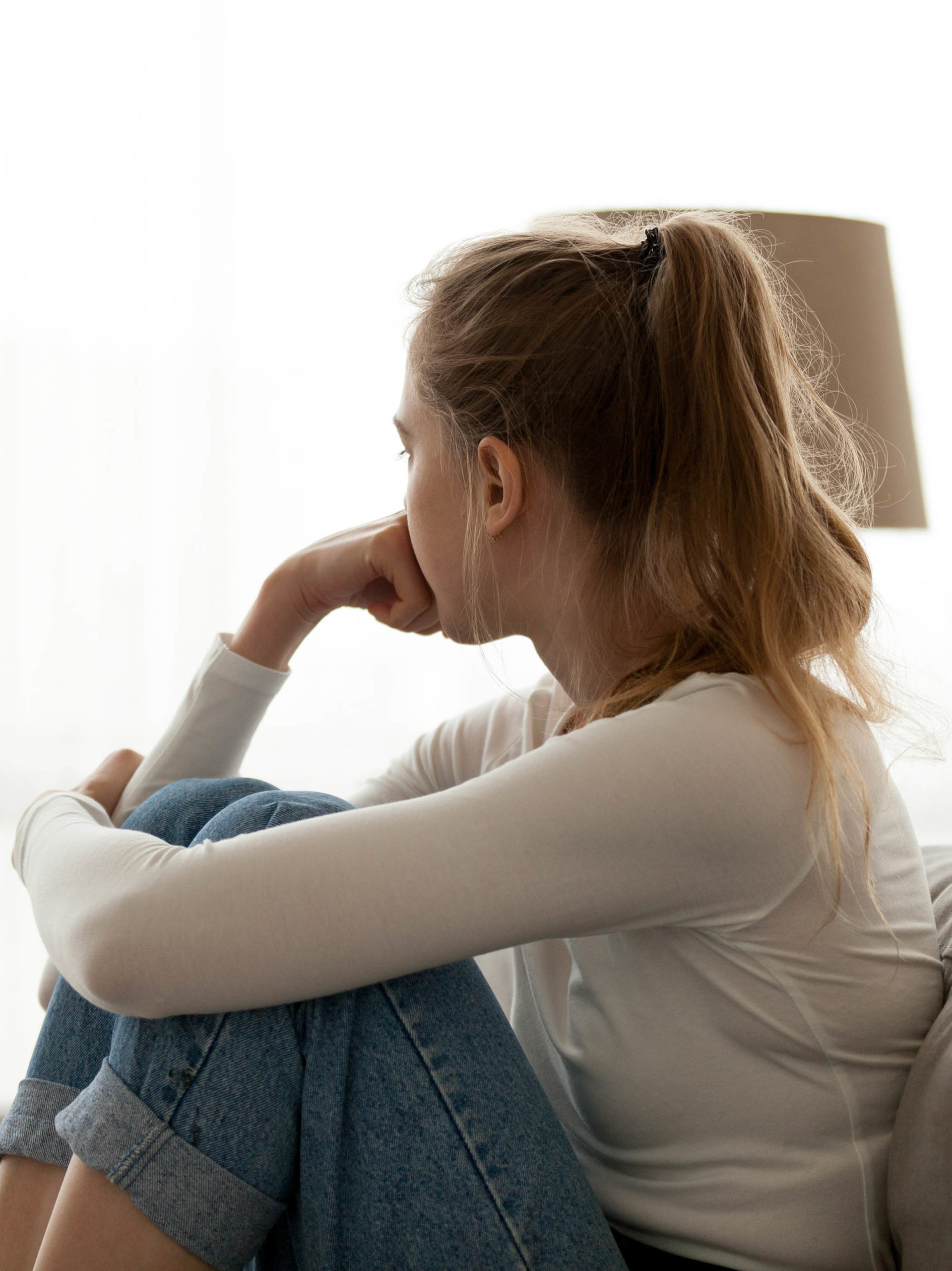 frustrated unhappy teen girl looking out the window thinking