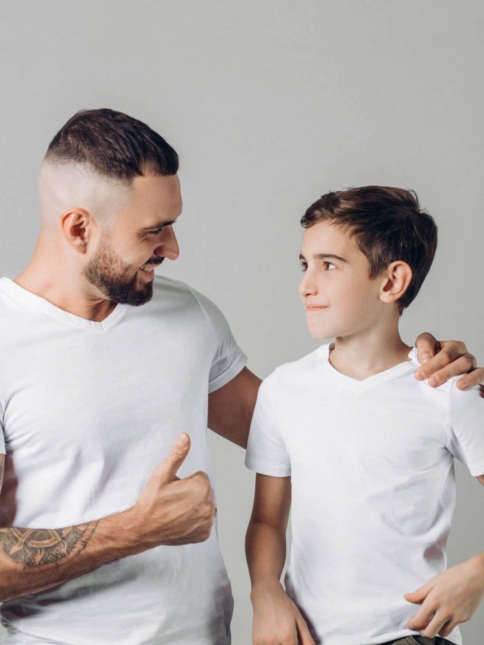 father assuring teen boy things will be ok with a smile and thumbs up