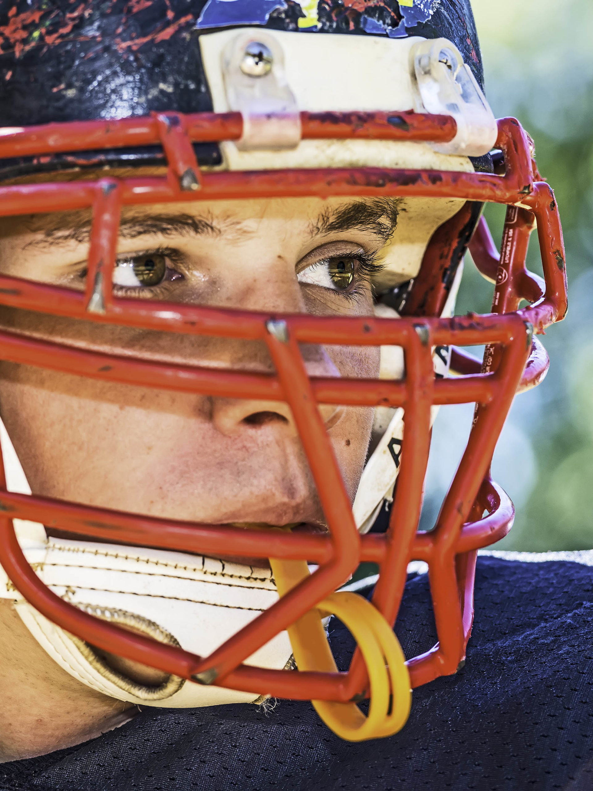 closeup of Football Player with a heavily worn helmet