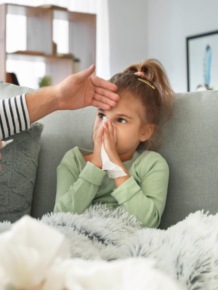 Father taking care of his daughter ill with flu at home