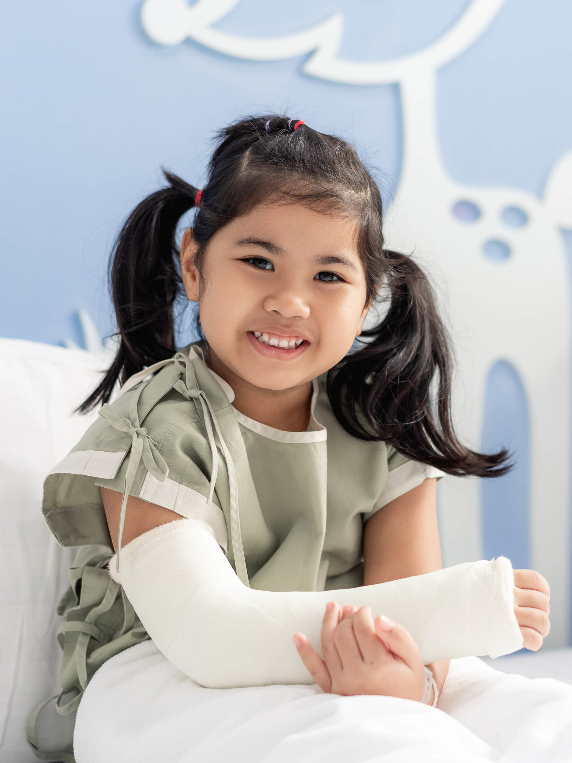 girl in hospital bed with broken arm in a cast