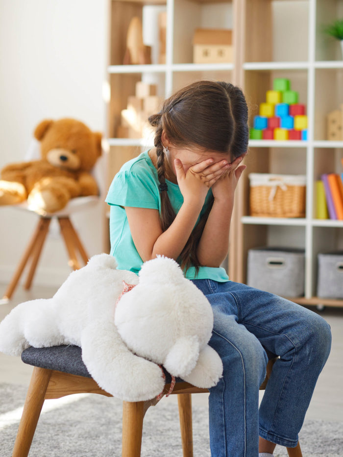 Bullied little schoolgirl crying in psychologist's office unable to control emotions