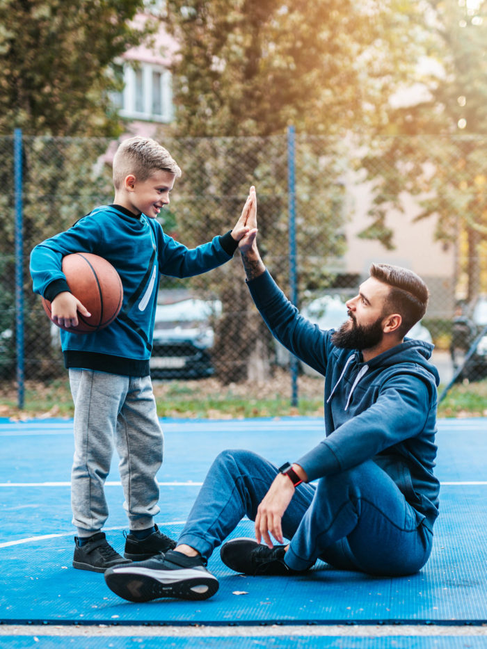 Father and his son enjoying time together on basketball court