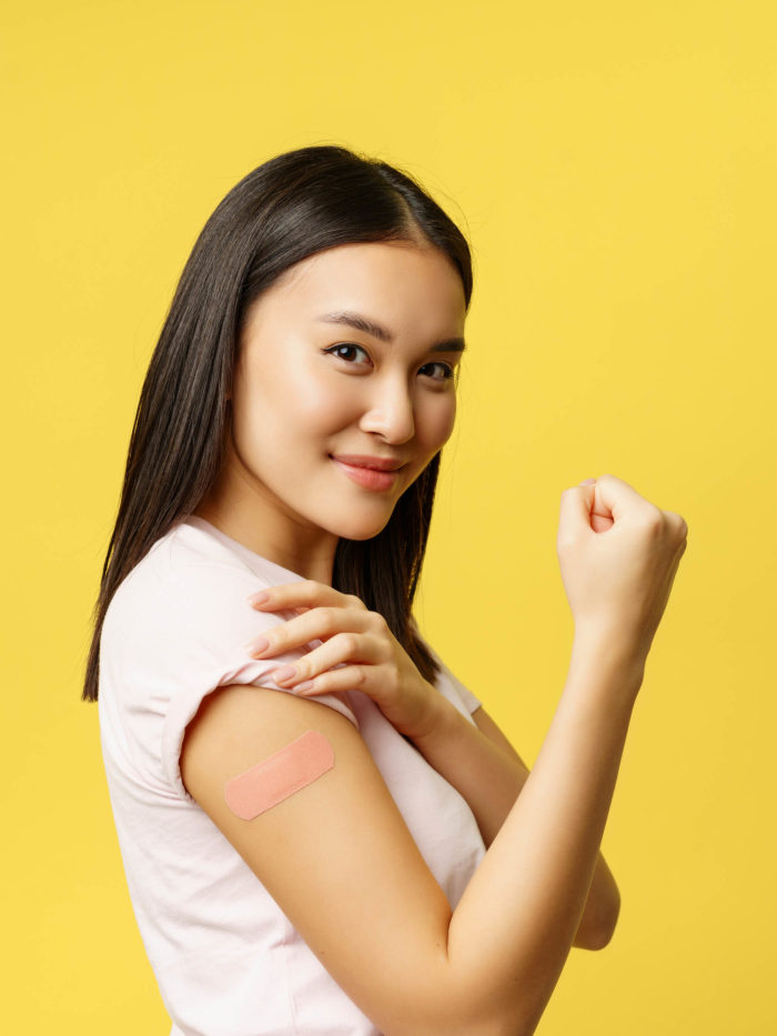 teen girl showing patch from coronavirus vaccine on arm