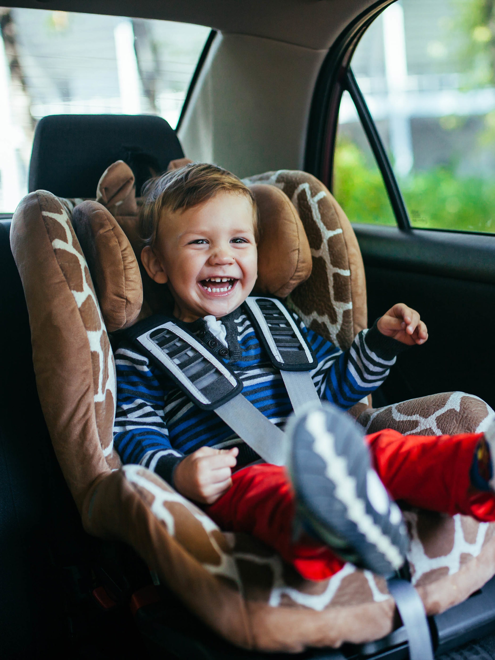 toddler smiling and laughing in car seat