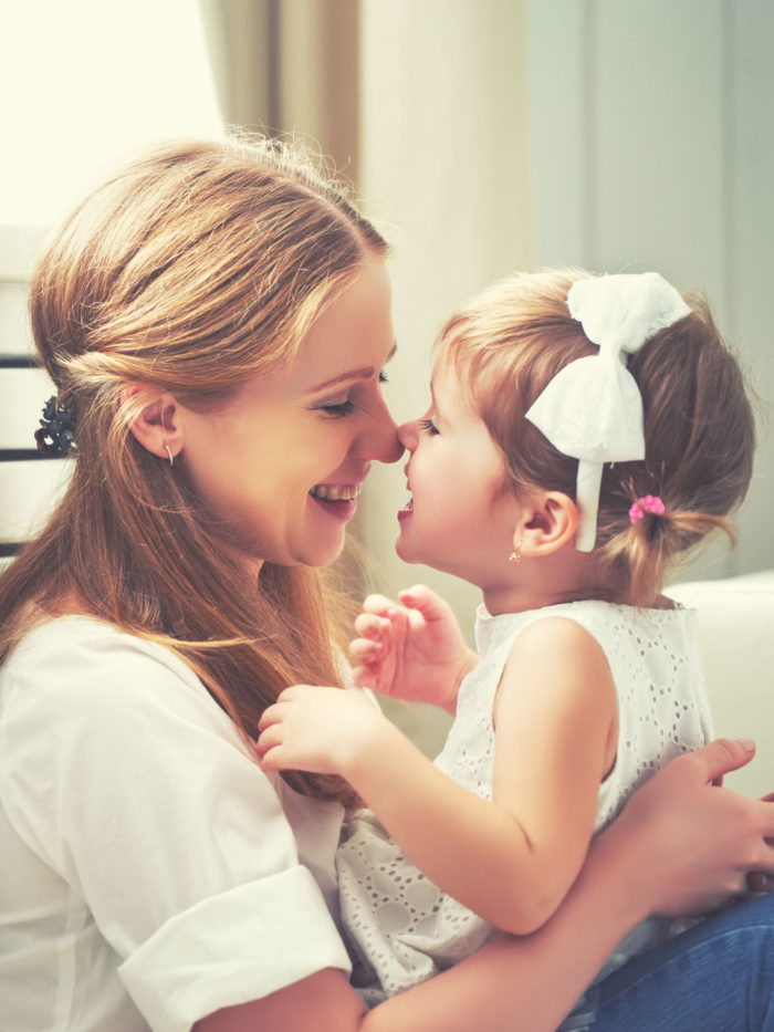 mother and child girl happily rubbing their noses together