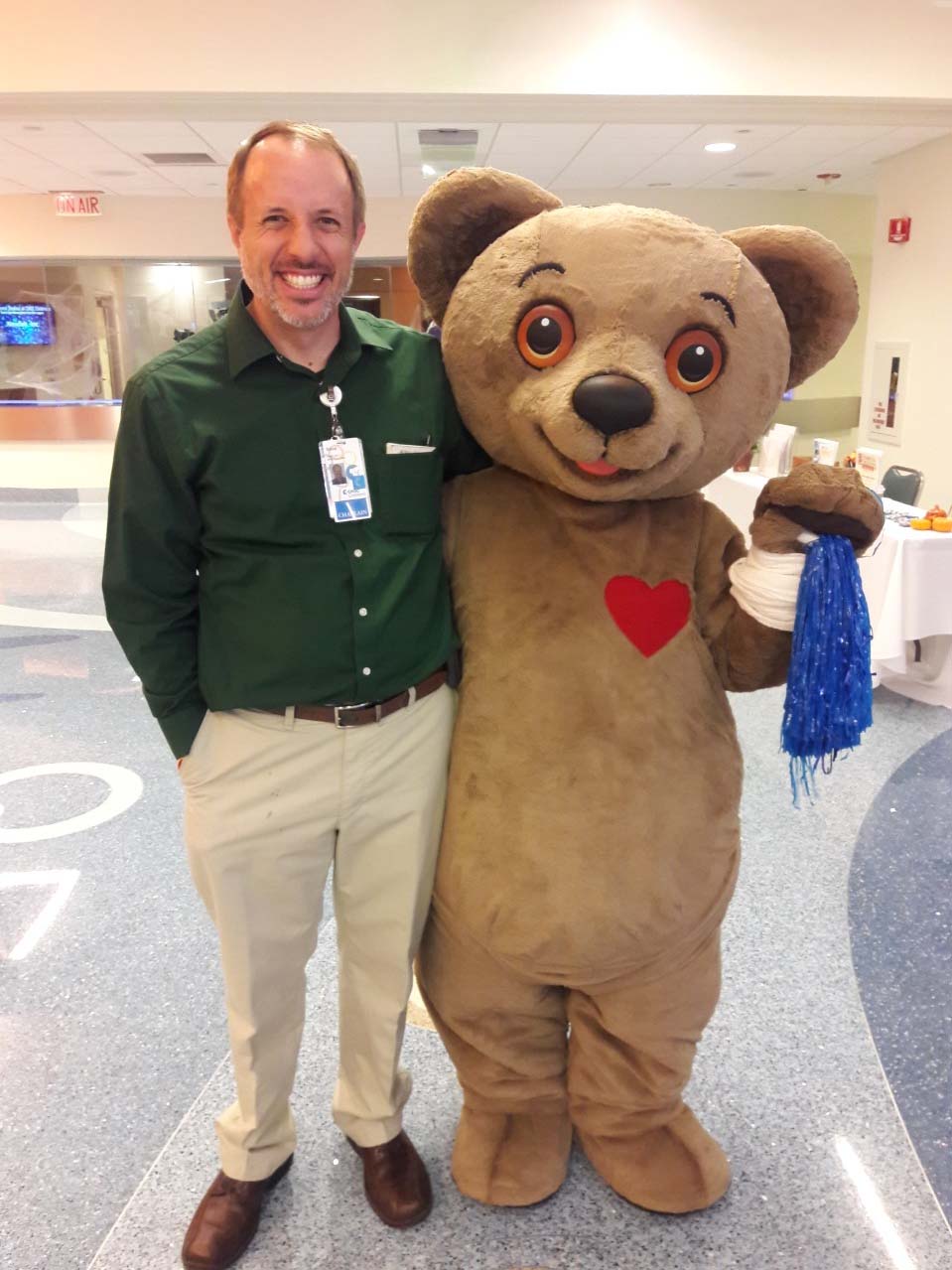 Chaplain Steve standing with Choco Bear mascot in CHOC hospital