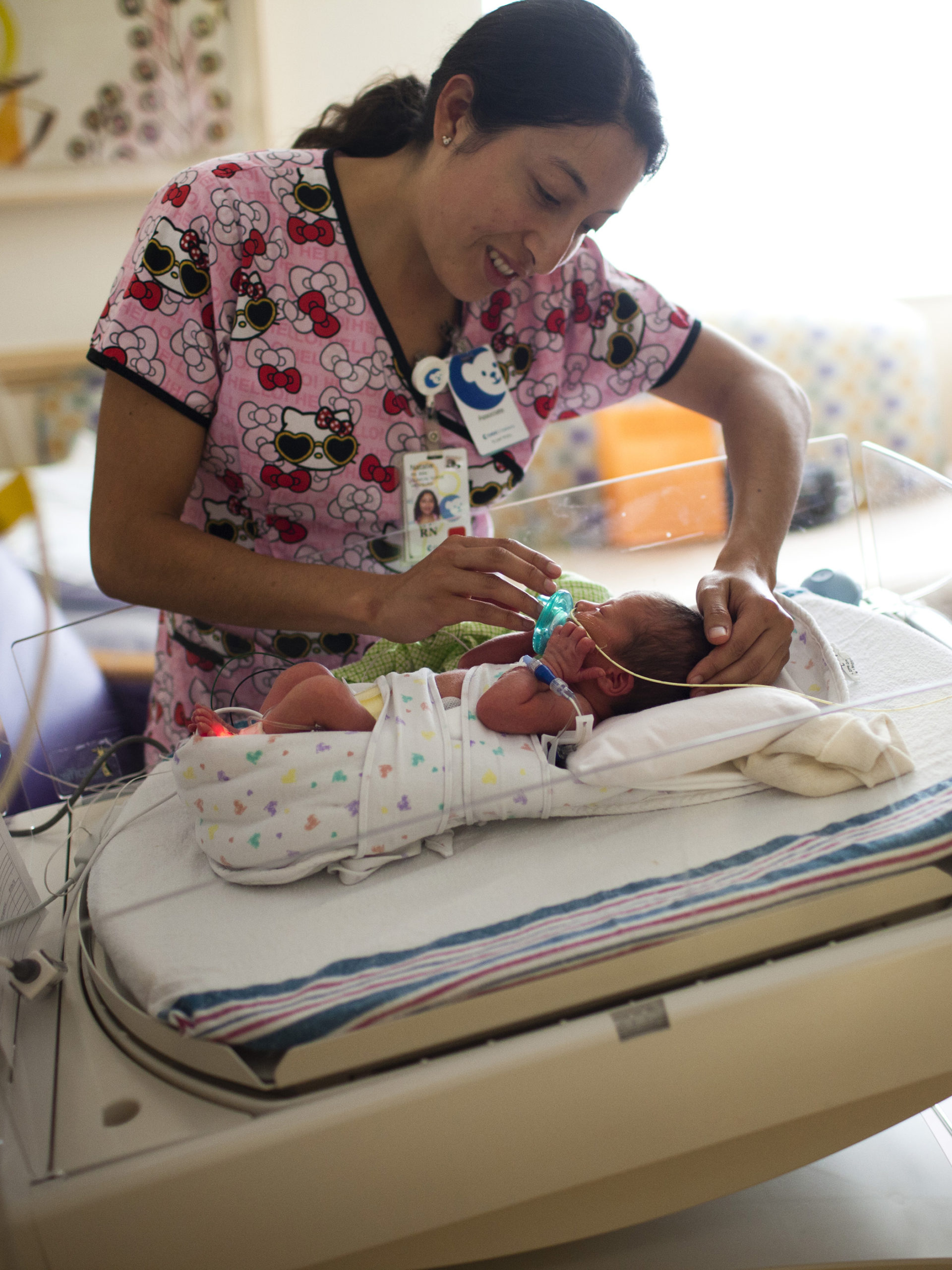 CHOC NICU nurse giving a pacifier to baby in NICU